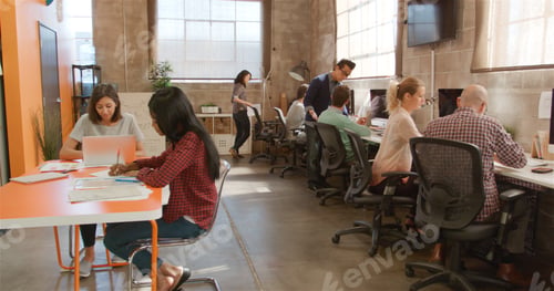 Preview: Designers In Creative Business Working At Desks In Modern Open Plan Multi-Cultural Office