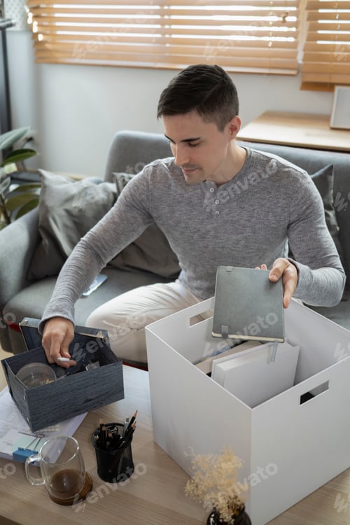 Preview: Young man preparing personal stuff for moving into new house.