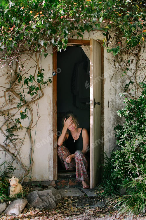 Preview: Serene moment at a rustic doorway framed by foliage.