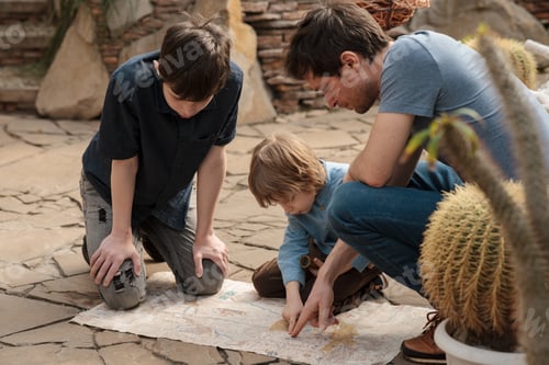 Preview: Three travelers inspect a map of the desert gallery in the Botanical Garden. Local travel