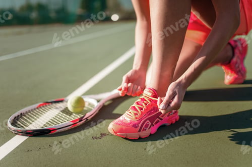 Preview: Female tennis player tying laces on sneakers