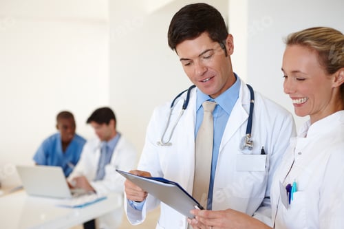 Preview: Shot of a male doctor and a female nurse discussing medical records