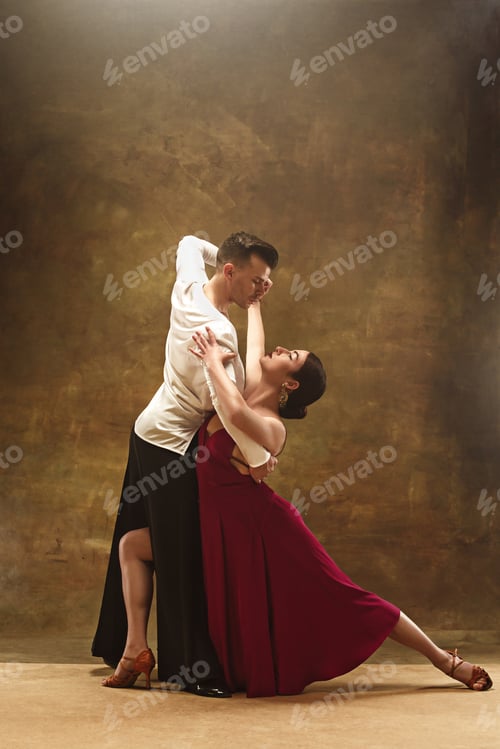 Preview: Dance ballroom couple in red dress dancing on studio background.