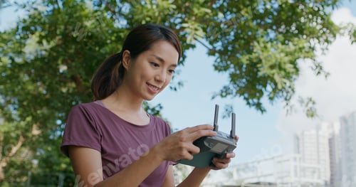 Preview: Woman control a fly drone at outdoor