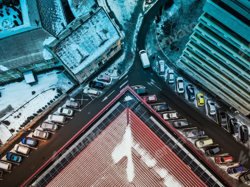 Preview: Aerial view of cars parked diagonally in a city street during winter