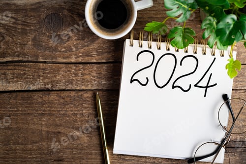 Preview: New year resolutions 2024 on desk. 2024 goals list with notebook, coffee cup, plant on wooden table