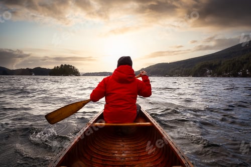 Preview: Adventure Man on a wooden canoe is paddling in the ocean