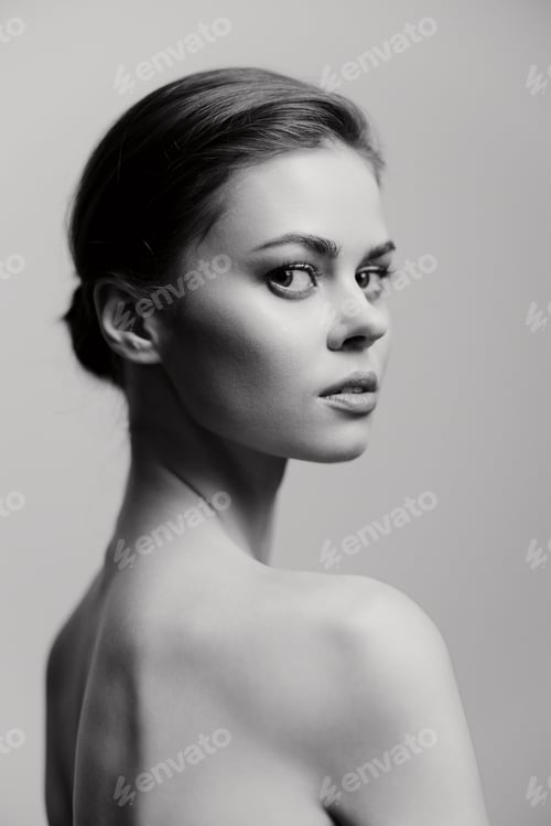 Preview: Graceful young woman with an elegant posture, gazing thoughtfully over her shoulder. Monochrome