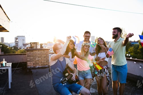 Preview: Group of happy friends having party on rooftop
