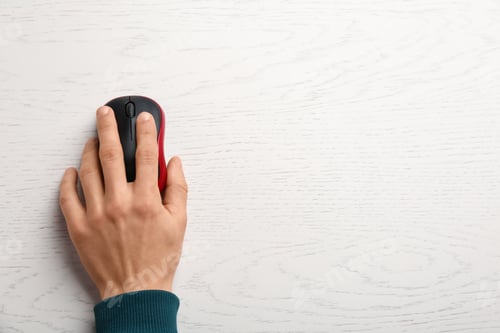 Preview: Man using computer mouse on wooden table, top view. Space for text