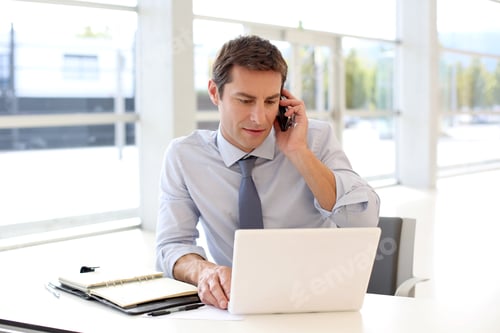 Preview: Portrait Of Businessman Talking On Mobile Phone In Office