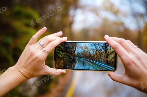 Preview: A female hand holding an mobile Phone to take a photo