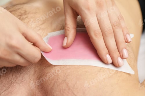 Preview: Young man undergoing wax epilation in salon, closeup