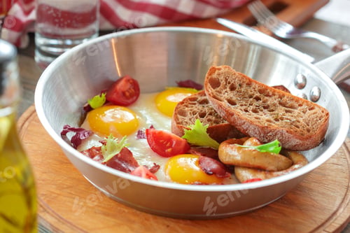 Preview: Breakfast with eggs, bacon, tomatoes, and toast on a wooden table in a cafe setting