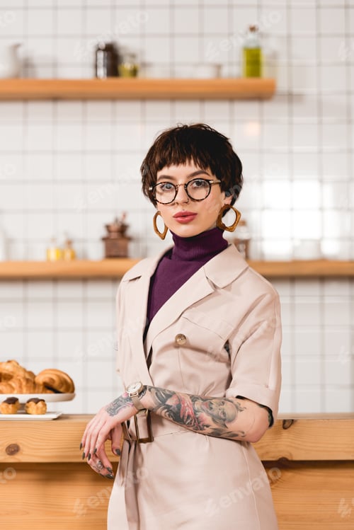 Preview: trendy, attractive businesswoman standing near bar counter in cafeteria