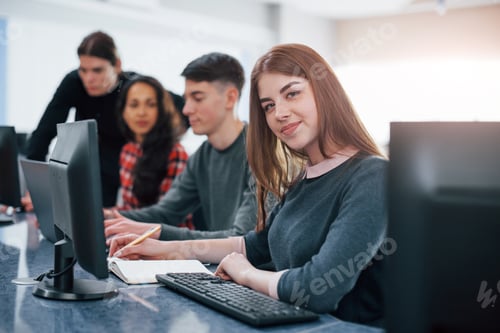 Preview: Pretty girl. Group of young people in casual clothes working in the modern office