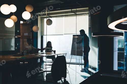 Preview: Colleagues working in dark office