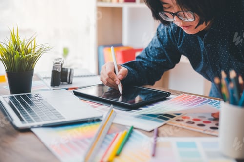 Preview: Graphic designer architects who work with laptops and color comparison tables for design work.