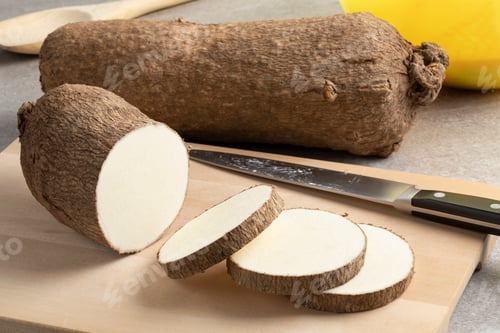 Preview: Whole and sliced raw African yam on a cutting board