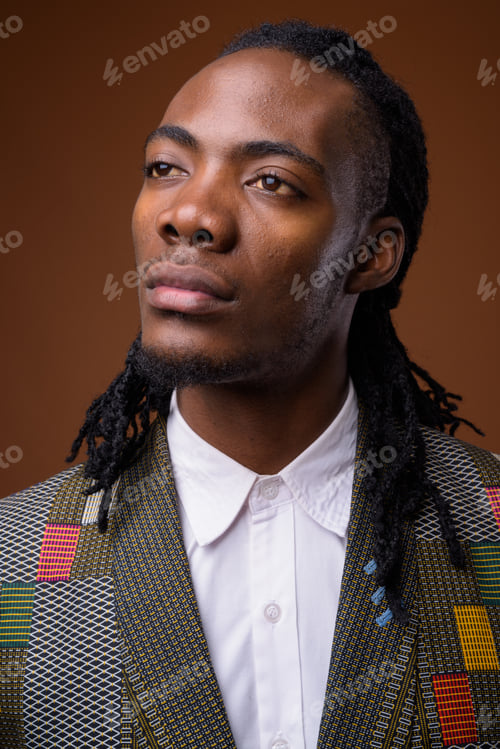 Preview: Young handsome African businessman against brown background