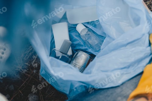 Preview: High angle shot of a plastic garbage bag with recyclable bottles - environmental pollution concept