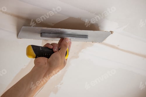 Preview: man plastering ceiling, repair. Selective focus