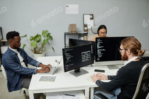 Preview: Group of intercultural software engineers working in front of computer monitors