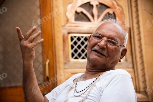Preview: Happy senior Indian man in front of his house