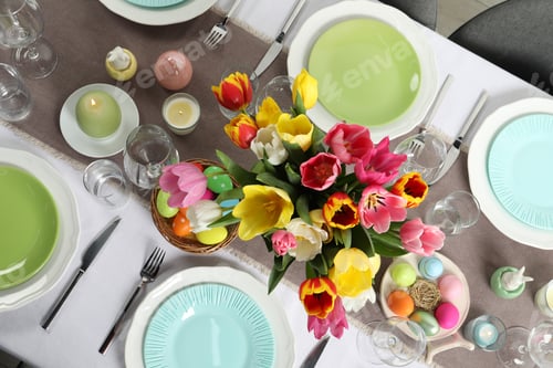 Preview: Easter celebration. Festive table setting with beautiful flowers and painted eggs, top view