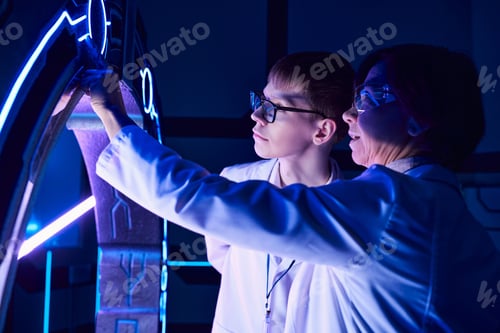 Preview: scientific discovery, woman scientist and young intern exploring device in discovery center