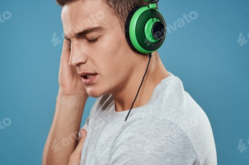Preview: Man in green headphones listens to music entertainment lifestyle white t-shirt blue background