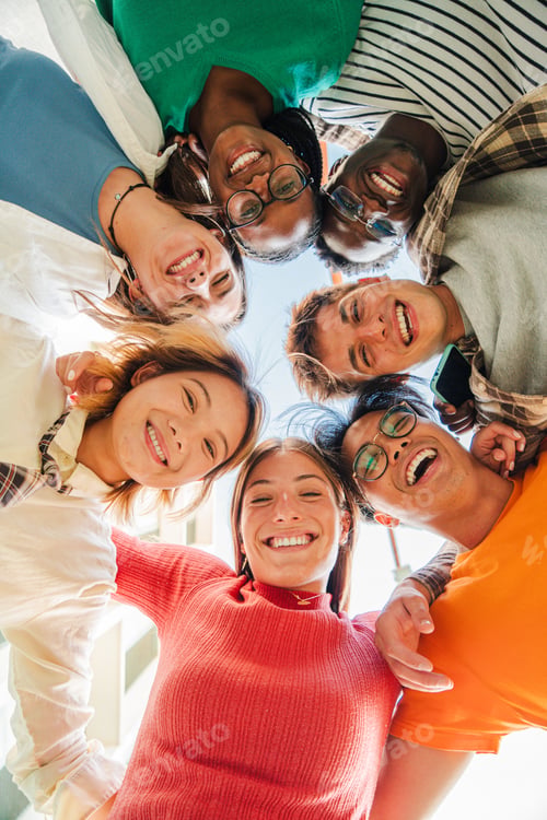 Vista previa: Vertical low angle view of a group of multiracial friends standing on a circle, smiling and