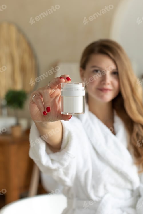 Preview: Woman Holding Cosmetic Cream Jar in Bathroom