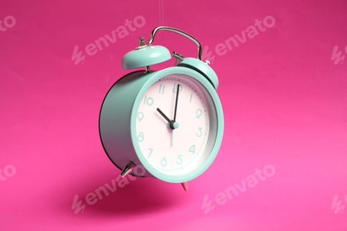 Preview: Turquoise alarm clock in air on bright pink background
