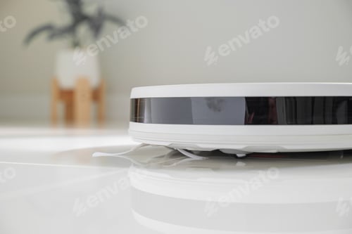 Preview: White automatic floor cleaner with side brush on tile flooring, featuring front black sensor strip