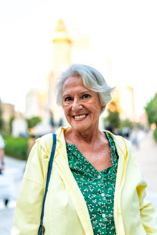 Preview: Happy elder modern woman standing in the city