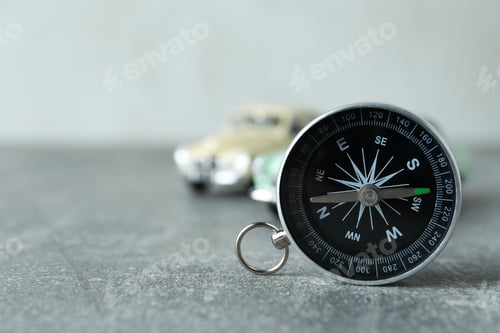 Preview: A compass on a table with a car.