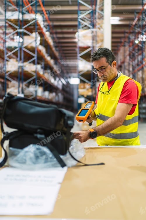Preview: Warehouse worker scanning package with barcode scanner
