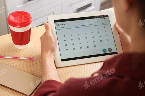 Preview: Woman using calendar app on tablet in office, closeup