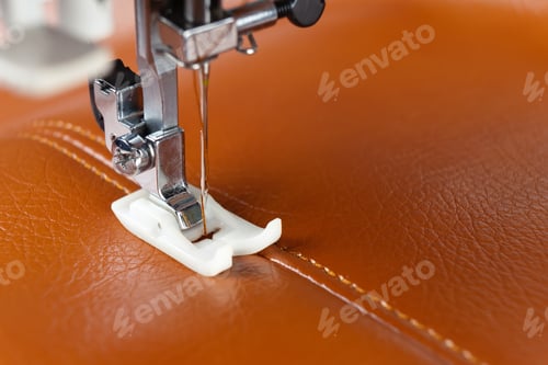 Preview: Modern sewing machine presser foot with a needle sews brown leather