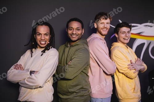 Preview: Carefree multiethnic friends crossing arms and looking at camera in gaming club