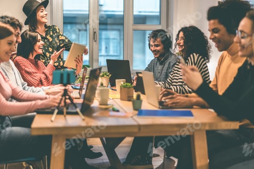 Preview: Young business team working inside coworking office - Soft focus on center man face