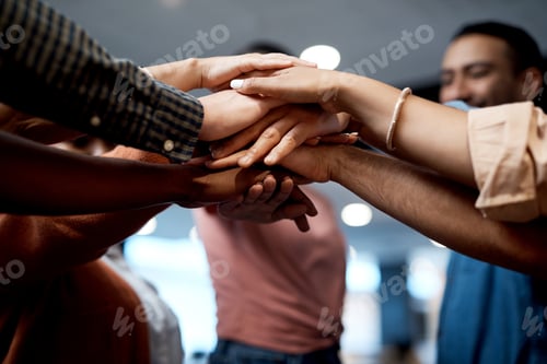 Preview: Shot of a group of businesspeople joining hands in solidarity in a modern office