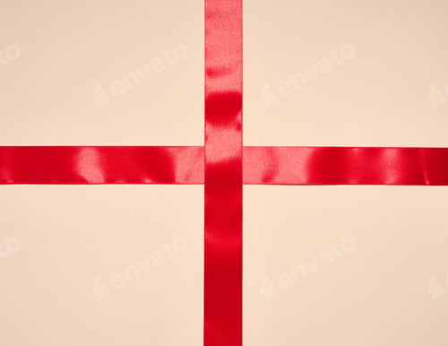 Preview: Red silk ribbon on a beige background, top view