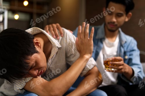 Preview: Drunk man sitting on sofa refusing whiskey from his friend by raising his hand to stop.