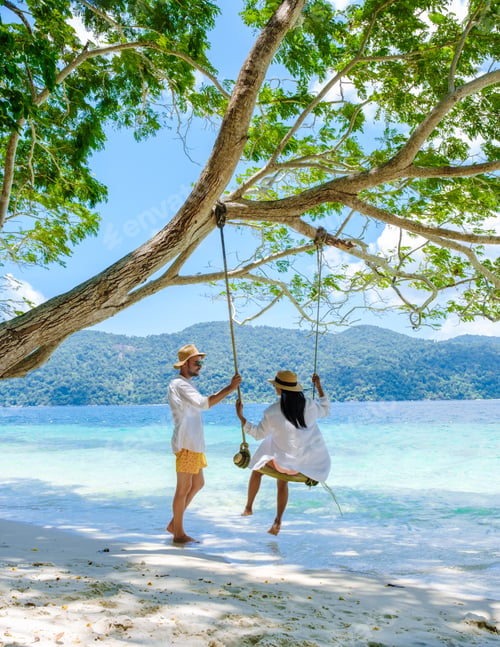 Preview: A couple of men and women are on the beach with a rope swing