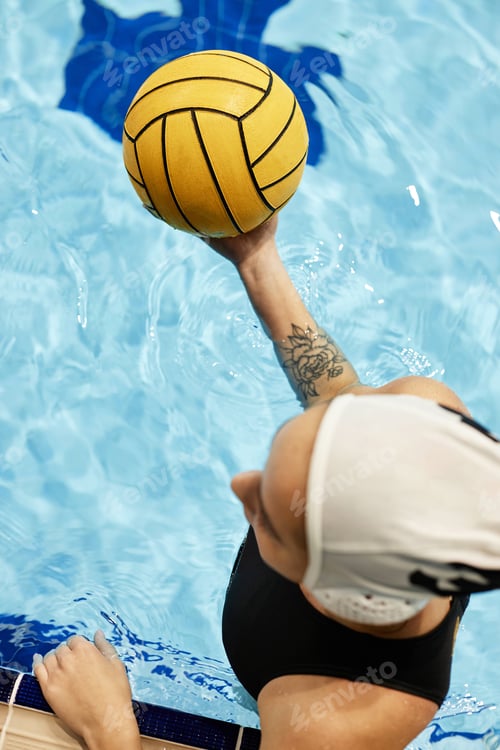 Preview: Top view of young female athlete in swimwear holding yellow ball