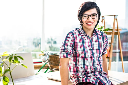 Preview: Smiling hipster businessman posing for camera in office