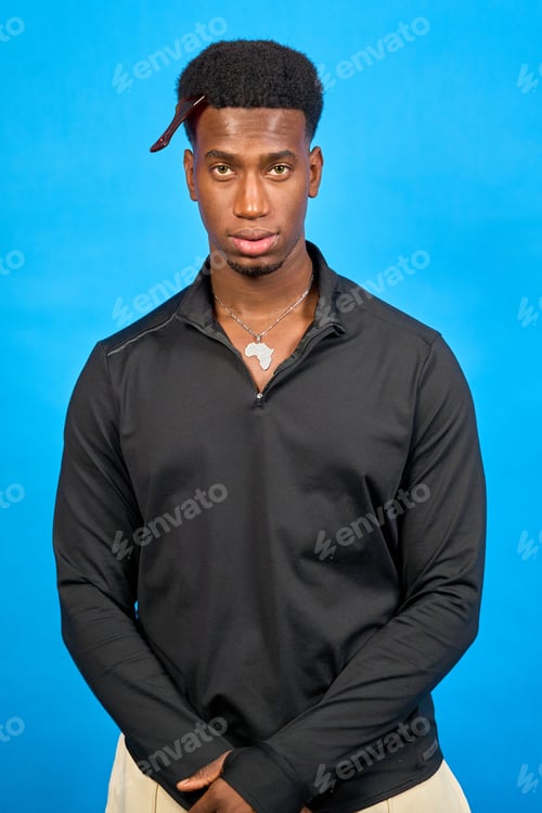 Preview: Young black man wearing africa pendant posing on blue background