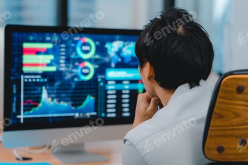 Preview: Asian young businessman using desktop computer thinking of inspiration in modern office workplace.